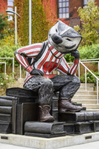"Well Red," a sculpture by artist Douwe Blumberg of a studious-looking UW-Madison mascot Bucky Badger sitting atop a pile of books, is pictured at Alumni Park at the University of Wisconsin-Madison during autumn on Oct. 30, 2021. (Photo by Jeff Miller / UW–Madison)